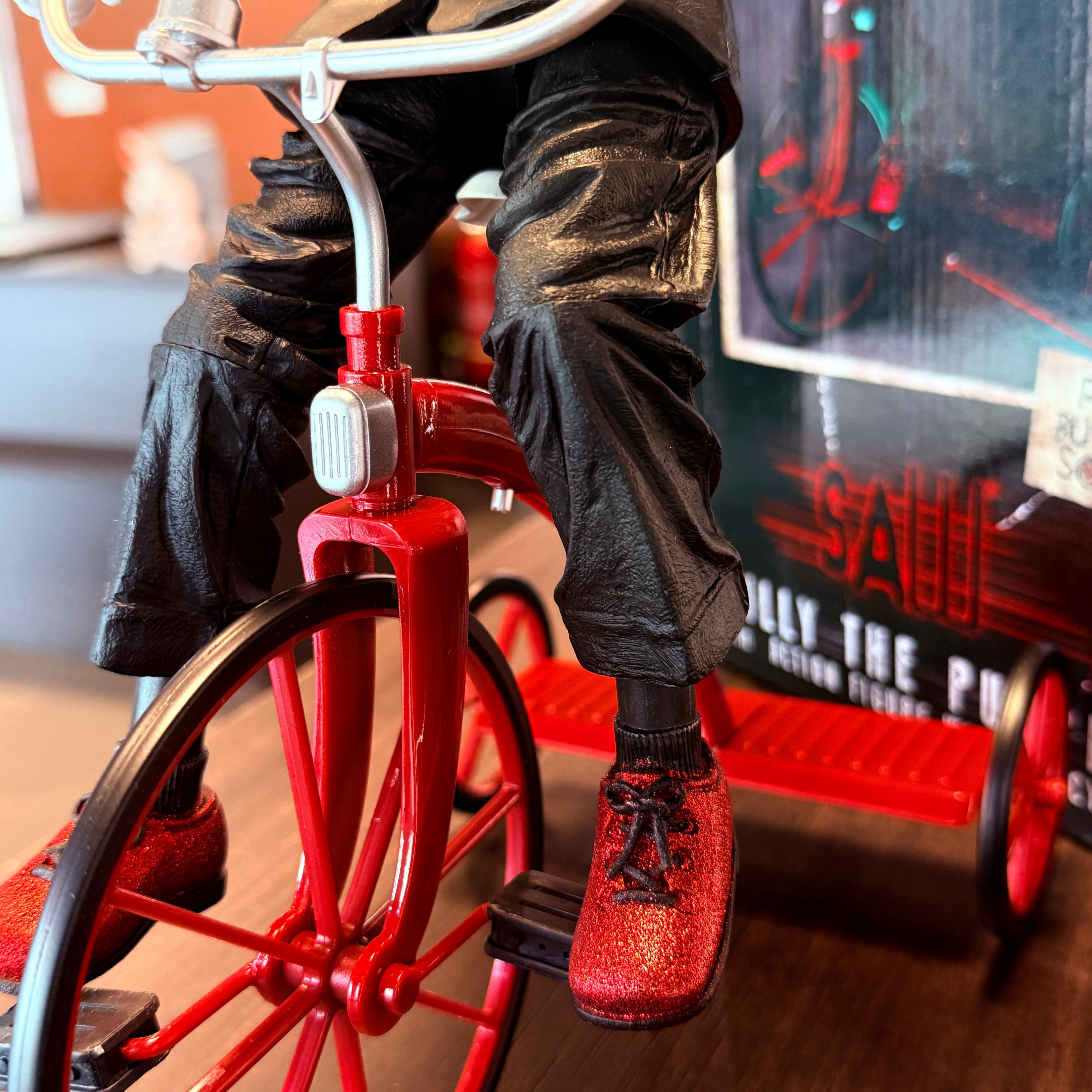 Fűrész Billy, a baba 12 hüvelykes akciófigurája triciklivel a NECA-tól